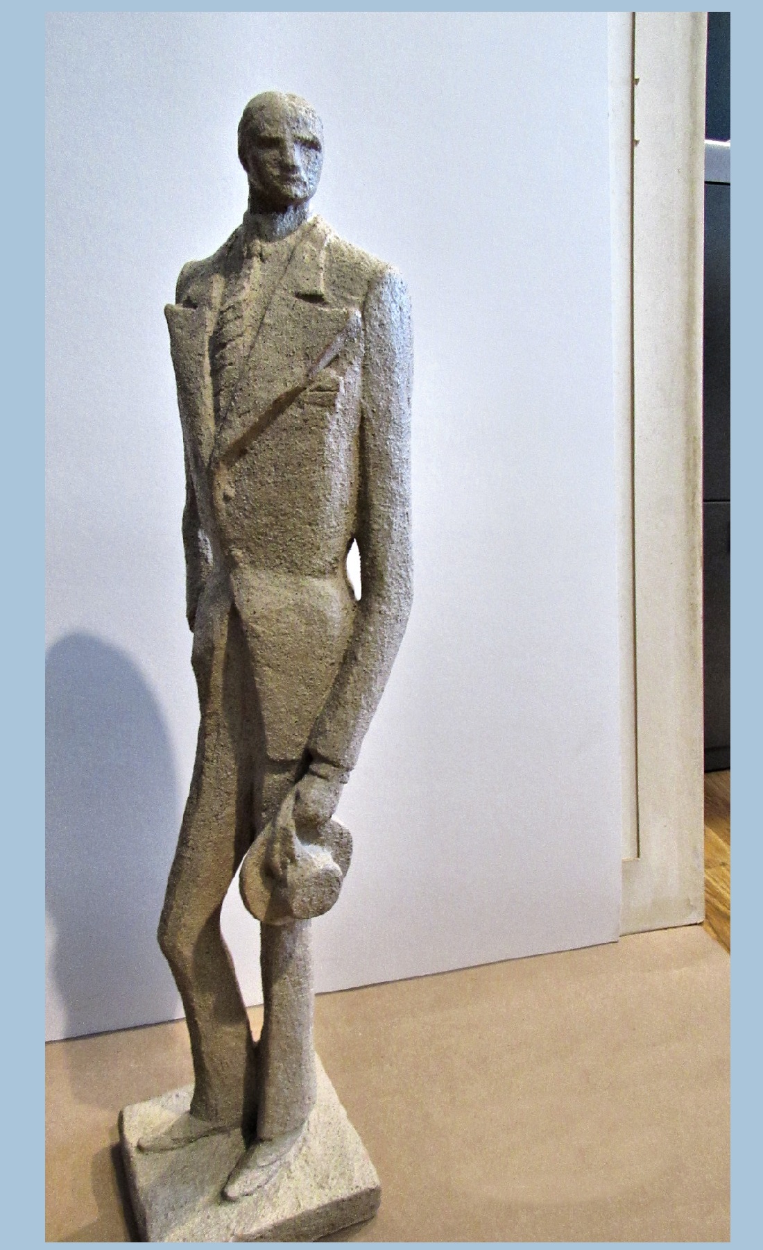 Narrow and tall clay sculpture of a man