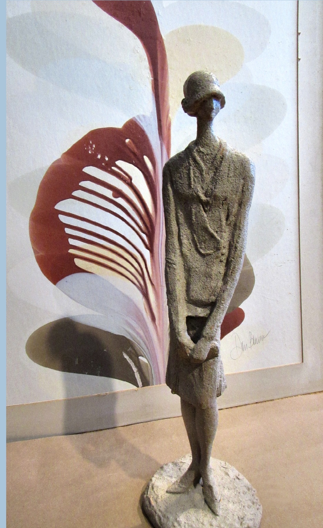 Narrow and tall clay sculpture of a woman